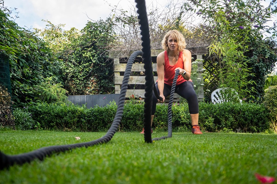 Kathryn training outdoors with battle ropes